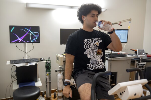 College student and research subject Sam Srisatta pedals on a stationary bicycle as part of an exercise session during a study on the health effects of ultraprocessed foods at the National Institutes of Health in Bethesda, Md., on Thursday, Oct. 31, 2024. (AP Photo/Mark Schiefelbein)