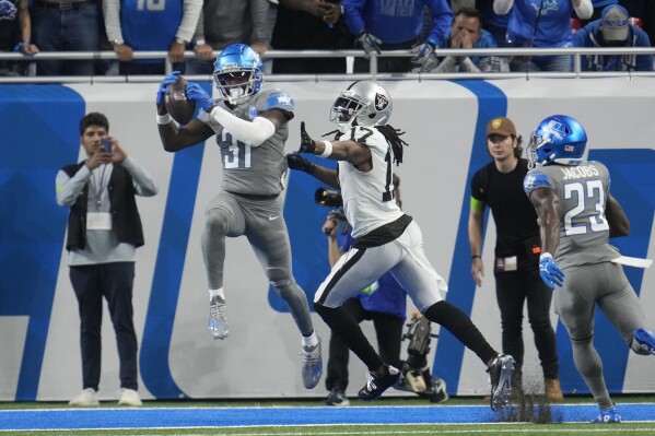 Detroit Lions safety Kerby Joseph (31) intercepts a pass intended for Las Vegas Raiders wide receiver Davante Adams (17) during the first half of an NFL football game, Monday, Oct. 30, 2023, in Detroit. (AP Photo/Paul Sancya)