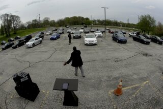 FILE - In this April 12, 2020 file photo, Pastor W.R. Starr II preaches during a drive-in Easter Sunday service while churchgoers listen from their cars in the parking lot at Faith City Christian Center in Kansas City, Kan. As states grapple with when and how to reopen establishments amid the coronavirus pandemic, churches and nonprofits across the country are defending their religious freedom in court, finding success in the less polarizing practice of a drive-in worship designed to gather the faithful in person, at a distance. (AP Photo/Charlie Riedel, File)