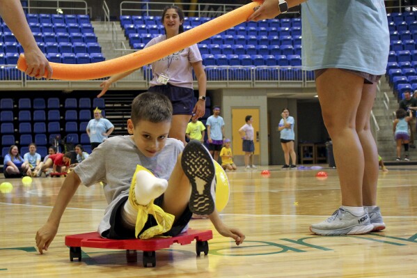 Camper Conor Dwyer participates in an obstacle course during Camp No Limits at Quinnipiac University, Friday, July 14, 2023 at Quinnipiac University in Hamden, Conn. Camp No Limits is helping train students at Quinnipiac University with a four-day program, run and staffed by students in the university's physical and occupational therapy program on the school's campus. (AP Photo/Pat Eaton-Robb)