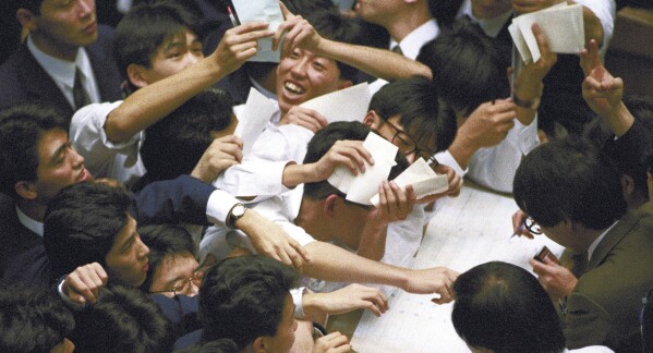 Stock traders are seen at Tokyo Stock Exchange in Tokyo, on Dec. 29, 1989. Japan’s benchmark Nikkei 225 index surged Thursday past the record it set in 1989 before its financial bubble burst, ushering in an era of faltering growth. The index closed Thursday at 39,098.68, up 2.2%. It had been hovering for weeks near 34-year highs. Its previous record was 38,915.87, set on Dec. 29, 1989. (Kyodo News via AP)