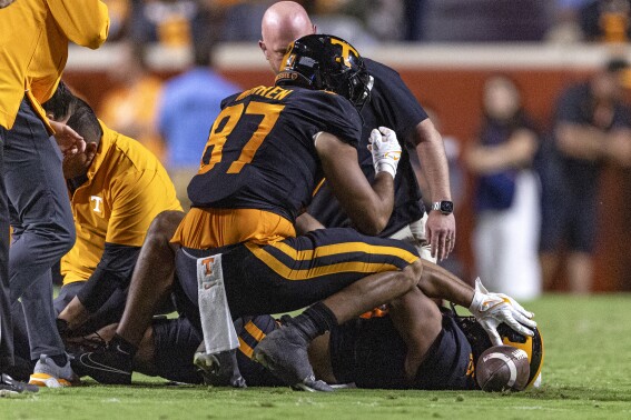 Tennessee wide receiver Bru McCoy (15) lies on the field after being injured, while tight end Jacob Warren (87) checks on him during the first half of the team's NCAA college football game against South Carolina on Saturday, Sept. 30, 2023, in Knoxville, Tenn. (AP Photo/Wade Payne)