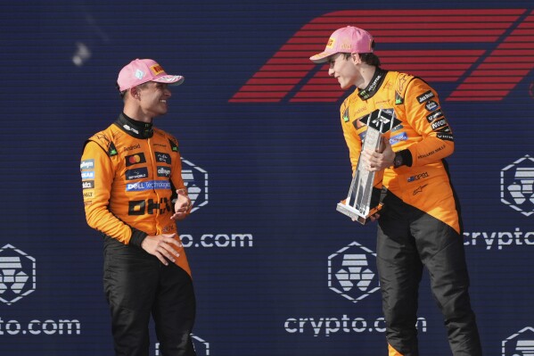 McLaren drivers Lando Norris of Britain, left, and Oscar Piastri of Australia celebrate on the podium after a first and second place finish in the Formula One Miami Grand Prix auto race Sunday, May 4, 2025, in Miami Gardens. Fla. (AP Photo/Marta Lavandier)