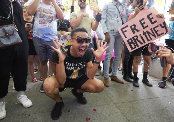 Britney Spears supporter Brian Molina of Los Angeles celebrates outside the Stanley Mosk Courthouse, Wednesday, Sept. 29, 2021, in Los Angeles. A judge on Wednesday suspended Britney Spears' father from the conservatorship that has controlled the singer's life and money for 13 years, saying the arrangement "reflects a toxic environment." (AP Photo/Chris Pizzello)