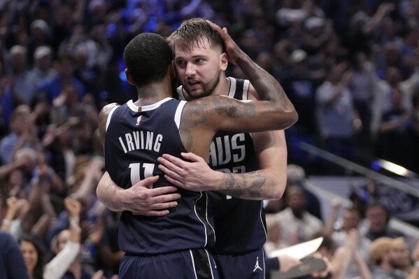 Dallas Mavericks' Kyrie Irving (11) and Luka Doncic, right, celebrate the team's win in Game 3 of an NBA basketball second-round playoff series against the Oklahoma City Thunder, Saturday, May 11, 2024, in Dallas. (AP Photo/Tony Gutierrez)