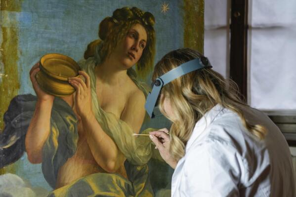 Restorer Elizabeth Wicks works on the "Allegory of Inclination", a 1616 work by Artemisia Gentileschi, in the Casa Buonarroti Museum, in Florence, Italy, Wednesday, Nov. 9, 2022. Restorers have begun a six-month project on the "Allegory of Inclination" using modern techniques including x-rays and UV infrared research to go beneath the veils painted over the original to cover nudities and discover the work as Gentileschi painted it. (AP Photo/Andrew Medichini)