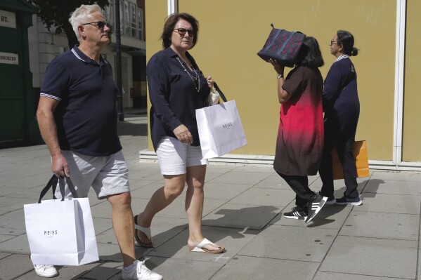 People walk along a street in a shopping district in central London, Tuesday, Aug. 22, 2023. Analysis of the Bank of England's latest Monetary Policy shows, the UK is due to be the slowest growing economy in the G7 as the bank's growth forecasts have been downgraded from 0.75% to 0.5%. (AP Photo/Kin Cheung)