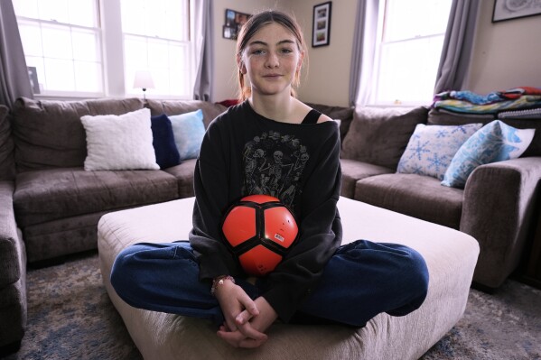 Parker Tirrell, a transgender athlete who plays on her high school's girls soccer team, poses in the living room of her family home, March 7, 2025, in Plymouth, N.H. (AP Photo/Charles Krupa, File)
