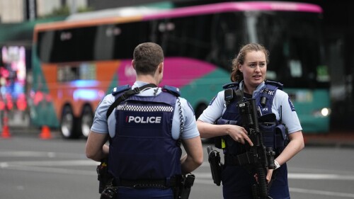 Armed New Zealand police officers stand outside a hotel housing a team from the FIFA Women's World Cup in the central business district following a shooting in Auckland, New Zealand, Thursday, July 20, 2023. New Zealand police are responding to reports that a gunman has fired shots in a building in downtown Auckland. (AP Photo/Abbie Parr)