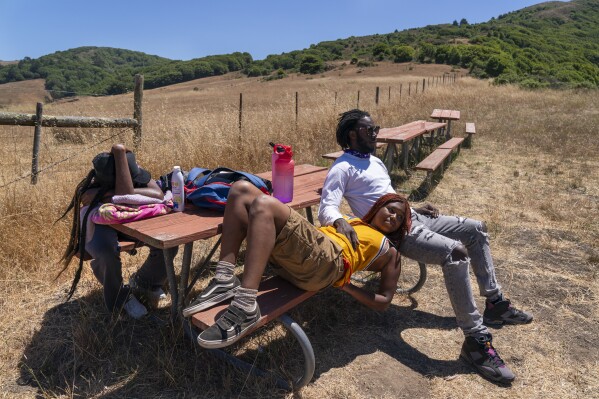 Camp counselors who have been attending this camp since they were also children, Ella Damaser, 22, of Cleveland, left, Satya Sheftel-Gomes, 22, of San Francisco, center, and Claude Lewis, 23, of Cleveland, relax near the lake at Camp Be’chol Lashon, a sleepaway camp for young Jews of color, Friday, July 28, 2023, in Petaluma, Calif., at Walker Creek Ranch. “The camp serves as an anchor, a safe space,” says Lewis, “I feel like this is a great place for multiple reasons, because one, yes, it's a very rare collection of Black Jews. But it's also a collection of minorities. It’s a safe place for people to explore who they are.” (AP Photo/Jacquelyn Martin)