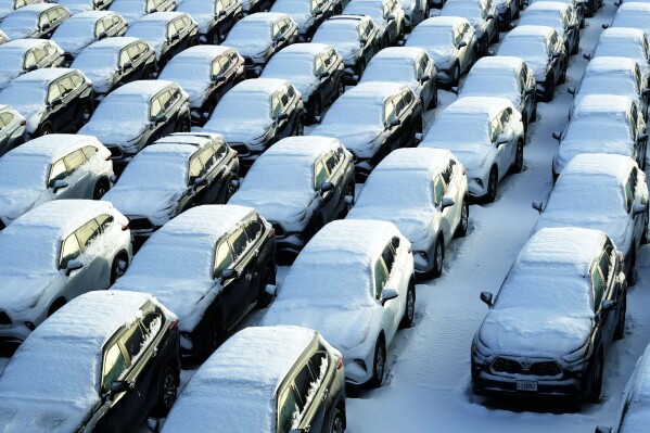 Snow-covered vehicles sit in a rental parking lot at O'Hare International Airport in Chicago, Sunday, Jan. 14, 2024. A wind chill warning is in effect as dangerously cold conditions persist in the Chicago area.  (AP Photo/Nam Wai. Ha)