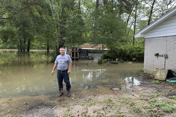 Miguel Flores senior stoi na zalanym podwórku przed swoim domem w dzielnicy Kingwood w północno-wschodnim Houston, sobota, 4 maja 2024 r.  Władze podały, że w ciągu około tygodnia w regionie spadły cztery miesiące deszczu.  (AP Photo/Juan Lozano)