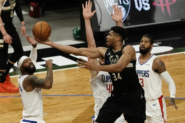 Milwaukee Bucks' Giannis Antetokounmpo shoots past LA Clippers' Paul George, Marcus Morris Sr. and Ivica Zubac during the second half of an NBA basketball game Sunday, Feb. 28, 2021, in Milwaukee. (AP Photo/Morry Gash)