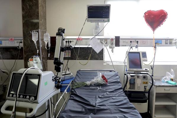 A heart-shaped balloon and a bouquet of roses adorn the bed of a man who died from COVID-19  at the ICU unit of the Shohadaye Tajrish Hospital in Tehran, Iran, Sunday, April 18, 2021. After facing criticism for downplaying the virus last year, authorities have put partial lockdowns and other measures in place to try and slow the coronavirus’ spread, as Iran faces what looks like its worst wave of the coronavirus pandemic yet. (AP Photo/Ebrahim Noroozi)