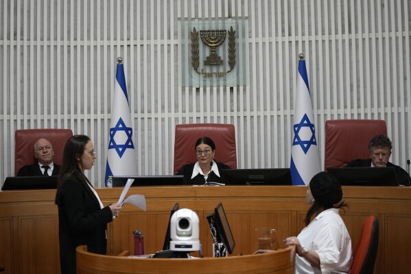 Esther Hayut, chief justice of the Supreme Court of Israel, center, sits on the bench with justices Uzi Vogelman, left, and Issac Amit, right, during a hearing on a petition against a law that limits removal of a prime minister from office to medical and mental incapacitation, which makes forcing Prime Minister Benjamin Netanyahu from office over a conflict of interest while on trial for corruption more difficult, in Jerusalem, Thursday, Aug. 3, 2023. (AP Photo/Ohad Zwigenberg)