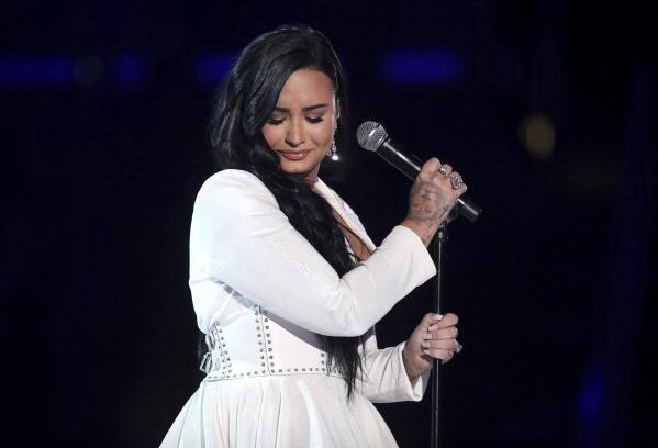 FILE - Demi Lovato performs "Anyone" at the 62nd annual Grammy Awards on Jan. 26, 2020, in Los Angeles. Lovato revealed on Wednesday, May 19, 2021, they identify as nonbinary and are changing their pronouns, telling fans the decision came after “self-reflective work.” Lovato said they picked gender-neutral pronouns them and they as “this best represents the fluidity I feel in my gender expression.” (Photo by Matt Sayles/Invision/AP, File)