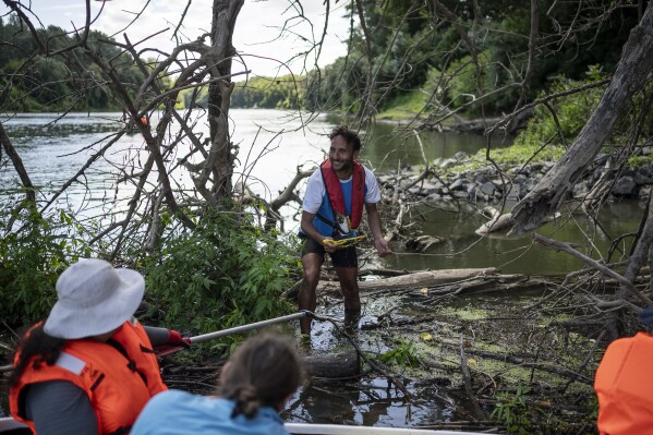 Volunteers collect rubbish from the banks of Tisza River near Tiszaroff, Hungary, Wednesday, Aug. 2, 2023. Life-jacketed rivergoers of all ages pile into dozens of canoes to scour Hungary’s second-largest river for trash that has flowed downstream. (AP Photo/Denes Erdos)