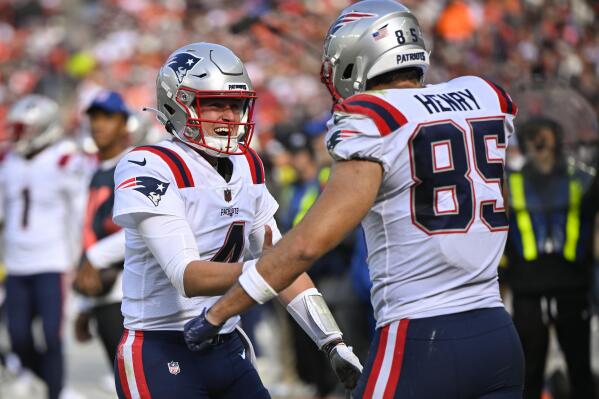 New England Patriots quarterback Bailey Zappe (4) celebrates after throwing a touchdown pass to tight end Hunter Henry (85) during the second half of an NFL football game against the Cleveland Browns, Sunday, Oct. 16, 2022, in Cleveland. (AP Photo/David Richard)