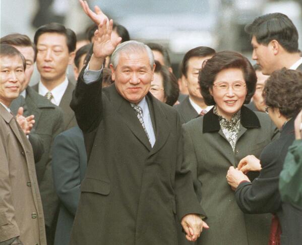 FILE - In this Dec. 22, 1997, file photo former South Korean President Roh Tae-woo, with his wife Kim Ok-sook standing beside him, waves to his supporters and neighbors upon arrival at his home after he was released from the Seoul prison in a special amnesty. Seoul hospital says Tuesday, Oct. 26, 2021, former South Korean President Roh has died (Yonhap via AP, Fiie)