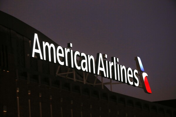 FILE - The American Airlines logo is stands atop the American Airlines Center, Dec. 19, 2017, in Dallas. Black passengers who were briefly ordered off an American Airlines plane in January sued the airline Wednesday, May 29, 2024, alleging that they were victims of racial discrimination. (AP Photo/Michael Ainsworth, File)