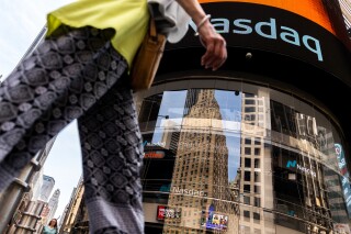 FILE - People walk past the Nasdaq MarketSite, July 13, 2022, in New York. A Dubai sovereign wealth fund that's the single-largest shareholder in the Nasdaq stock index plans to sell a third of its shares in the exchange, a deal potentially worth some $1.6 billion that saw the value of the firm fall in aftermarket trading Wednesday, March 20, 2024. (AP Photo/Julia Nikhinson, File)