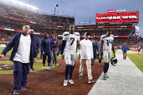 Seattle Seahawks quarterback Geno Smith (7) and wide receiver DK Metcalf (14) walk off the field after an NFL wild card playoff football game against the San Francisco 49ers in Santa Clara, Calif., Saturday, Jan. 14, 2023. The 49ers won 41-23. (AP Photo/Godofredo A. Vásquez)