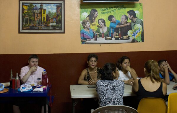 
              In this Aug. 18, 2018 photo, people eat inside a popular pupuseria, a restaurant serving traditional Salvadoran tortillas stuffed with savory fillings, in San Miguel, El Salvador. (AP Photo/Rebecca Blackwell)
            