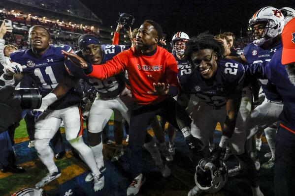 Auburn interim head coach Carnell Williams, center, celebrates with team after a win over Western Kentucky during the second half of an NCAA college football game, Saturday, Nov. 19, 2022, in Auburn, Ala. (AP Photo/Butch Dill)