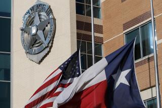 FILE - An American and Texas flag sit at half-staff outside of the Dallas Police Department headquarters, July 8, 2016, in Dallas. Dallas was hit with a computer ransomware attack that affected various websites, including the police department and municipal court, officials said Wednesday, May 3, 2023. (AP Photo/Tony Gutierrez, File)