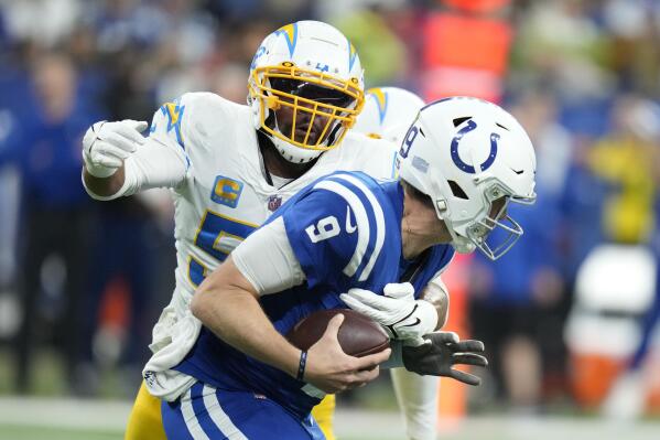 Indianapolis Colts quarterback Nick Foles (9) is sacked by Los Angeles Chargers' Khalil Mack (52) during the second half of an NFL football game, Monday, Dec. 26, 2022, in Indianapolis. (AP Photo/Michael Conroy)