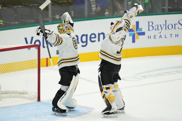 Boston Bruins goaltenders Jeremy Swayman, left, and Linus Ullmark react after an NHL hockey game against the Dallas Stars, Monday, Nov. 6, 2023, in Dallas. The Bruins won 3-2. (AP Photo/Julio Cortez)
