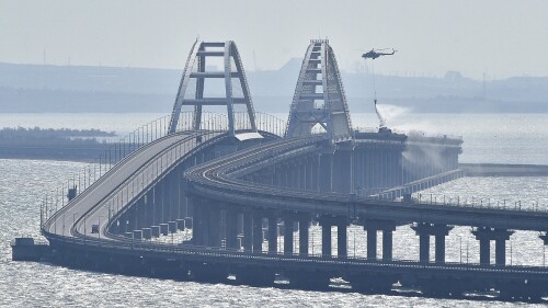 FILE - A helicopter drops water to stop fire on Crimean Bridge connecting Russian mainland and Crimean peninsula over the Kerch Strait, in Kerch, on Oct. 8, 2022. Traffic on the key bridge connecting Crimea to Russia’s mainland has been halted amid reports of explosions. The governor of Crimea, which was annexed by Russia in 2014, announced the closure early Monday, July 17, 2023, but did not specify the reason.(AP Photo, File)
