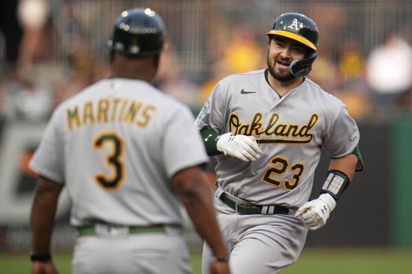 Oakland Athletics third baseman Jace Peterson, left, chases down a grounder  as Athletics shortstop Aledmys Diaz, right, looks on during the first  inning of a spring training baseball game against the San