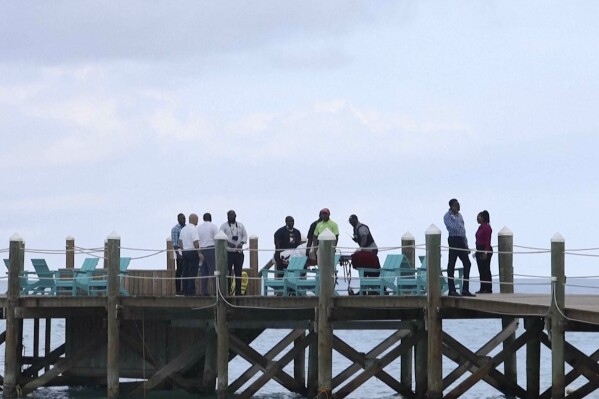 In this screen grab taken from video, lifeguards take the body of a shark victim out on a stretcher, in New Providence, Bahamas, Monday Dec. 4, 2023. (Freelance Media via AP)
