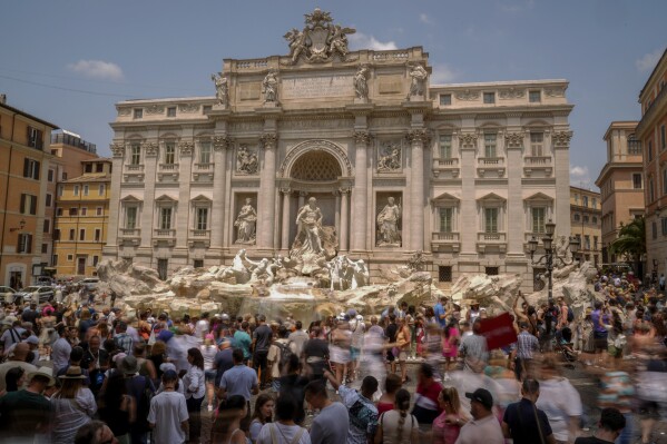 Tourists visit the Trevi Fountain in Rome, Friday, June 30, 2023. Crowds are packing the Colosseum, the Louvre, the Acropolis and other major attractions as tourism exceeds 2019 records in some of Europe’s most popular destinations. While European tourists helped the industry on the road to recovery last year, the upswing this summer is led largely by Americans, who are lifted by a strong dollar and in some cases pandemic savings. (AP Photo/Andrew Medichini)