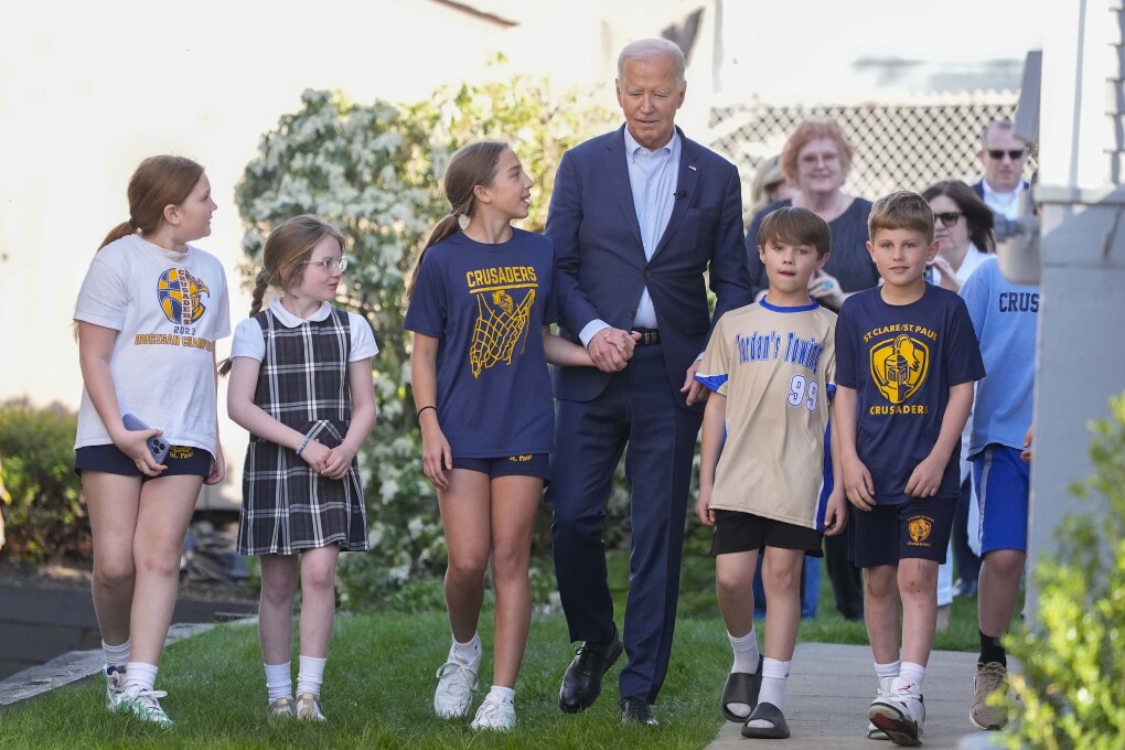President Joe Biden walks out of his childhood home with a group of unidentified children, Tuesday, April 16, 2024, in Scranton, Pa. (AP Photo/Alex Brandon)