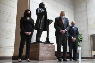 Standing near a statue of Frederick Douglass, Sen. Kamala Harris, D-Calif., left, Senate Minority Leader Sen. Chuck Schumer of N.Y., center, and Sen. Cory Booker, D-N.J.,, right, pause during a prayer Capitol Hill in Washington, Thursday, June 4, 2020, during an event to commemorate the life of George Floyd, who died after being restrained by Minneapolis police officers. (AP Photo/Susan Walsh)