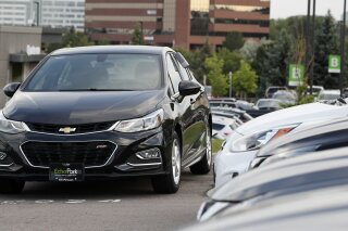 FILE - In this June 26, 2018, file photograph, a used 2017 Chevrolet Cruze sits in a row of other used, late-model sedans at a dealership in Centennial, Colo. A shortage of used vehicles in the U.S. has pushed up prices, and that caused much of September 2020's modest inflation increase. (AP Photo/David Zalubowski, File)