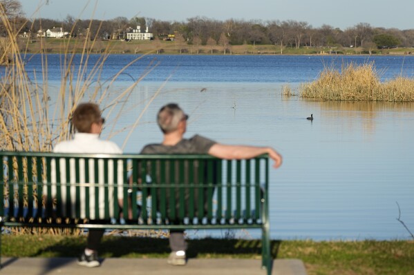 FILE - A couple sit along a trail overlooking White Rock Lake in Dallas on Feb. 24, 2024. Coming up with the best tax strategy in retirement can be much trickier than it seems, and tax pros agree that it is a time when people need to be especially careful. (Ǻ Photo/Tony Gutierrez-File)