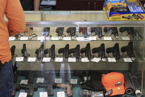 FILE - Handguns are displayed at a gun shop on June 23, 2022, in Honolulu. A U.S. judge is scheduled to consider on Friday, July 28, 2023, whether to temporarily stop Hawaii from enforcing a new state law that prohibits carrying a gun on beaches and other locations deemed sensitive. (AP Photo/Marco Garcia, File)