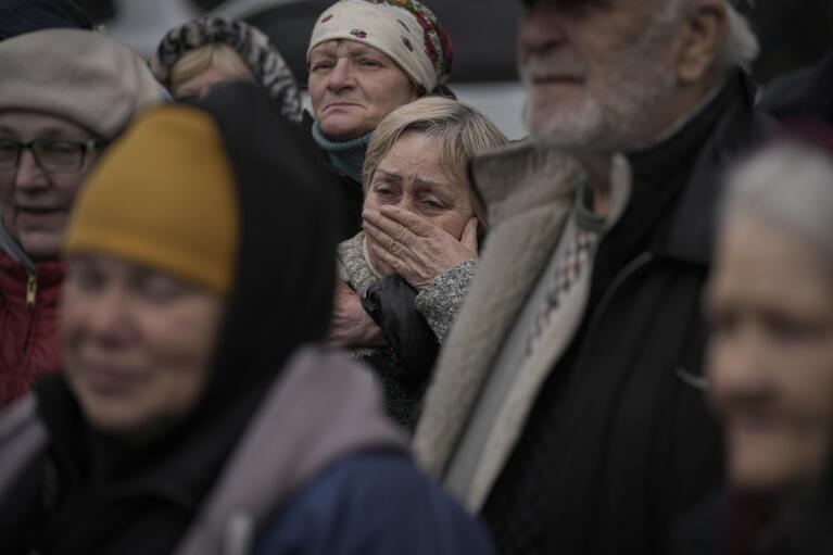 FILE - A woman cries as residents listen to a Ukrainian serviceman speaking after a convoy of military and aid vehicles arrived in the formerly Russian-occupied Kyiv suburb of Bucha, Ukraine, April 2, 2022. (AP Photo/Vadim Ghirda)