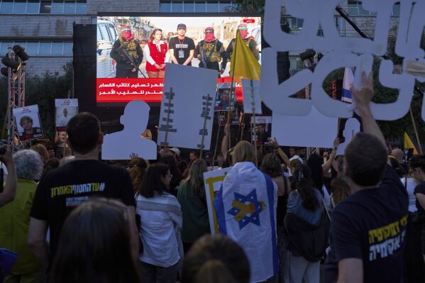 People watch a live broadcast of Israeli-American soldier Edan Alexander as he is released from Hamas captivity in Gaza, at a plaza known as the hostages square in Tel Aviv, Monday, May 12, 2025. Alexander was abducted during the Hamas-led attack on his base on October 7, 2023. (AP Photo/Oded Balilty)
