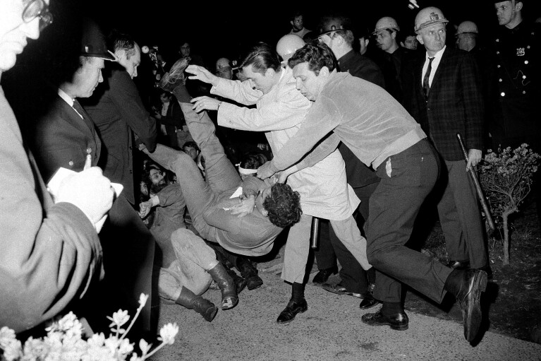 FILE - New York City plainclothes policemen drop a student protester on the ground after he and others holding a sit-in at Columbia University building were removed, April 30, 1968. (AP Photo/File)
