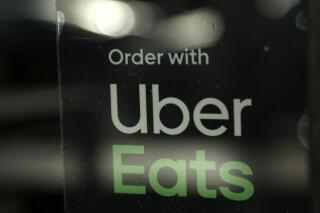 FILE - In this Nov. 6, 2019, file photo, a restaurant advertises Uber Eats in Miami. A civil rights group in Kansas said Tuesday, June 22, 2021 it has warned the food delivery service in a letter of a problem with profiles its app that it contends puts transgender drivers at risk. (AP Photo/Lynne Sladky, file)