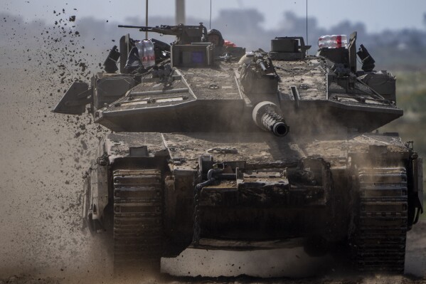 Israeli soldiers drive a tank on the border with Gaza Strip, in southern Israel, Tuesday, March 19, 2024. The army is battling Palestinian militants across Gaza in the war ignited by Hamas' Oct. 7 attack into Israel. (AP Photo/Ariel Schalit)