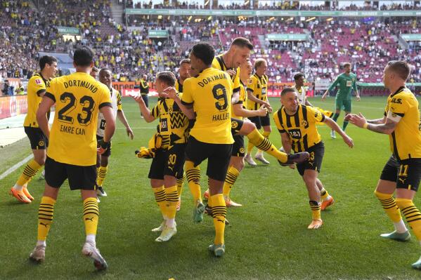 Borussia Dortmund players celebrate their victory at the German Bundesliga soccer match between FC Augsburg and Borussia Dortmund at the WWK Arena in Augsburg, Germany, Sunday, May 21, 2023. (AP Photo/Matthias Schrader)