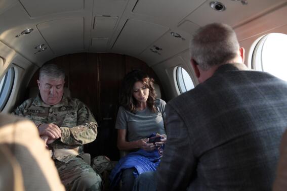 FILE - South Dakota Gov. Kristi Noem, center, checks her phone before taking off on July 26, 2021, in Pierre, S.D. A South Dakota prosecutor who was overseeing an investigation into Noem's use of state government aircraft announced Tuesday, Oct. 25, 2022, that the investigation found nothing to support a criminal prosecution. (AP Photo/Stephen Groves, File)