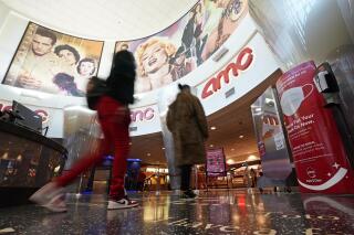 FILE - In this March 15, 2021, file photo movie patrons arrive to see a film at the AMC 16 theater in Burbank, Calif. AMC is looking to sell up to 11.5 million of its shares, as the movie theater operator looks to capitalize on its meme stock popularity. The announcement in a regulatory filing on Thursday, June 3 comes just two days after the company said it was raising $230.5 million through an 8.5 million share sale. (AP Photo/Mark J. Terrill, File)