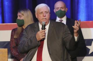 FILE - In this Nov. 3, 2020, file photo, West Virginia Gov. Jim Justice celebrates his reelection at The Greenbrier Resort in White Sulphur Springs, W.Va. A federal judge on Wednesday, July 21, 2021, blocked West Virginia from enforcing a new ban on transgender athletes. The law, signed by Justice in April, would prohibit transgender athletes from competing in female sports in middle and high schools and colleges. (AP Photo/Chris Jackson, File)