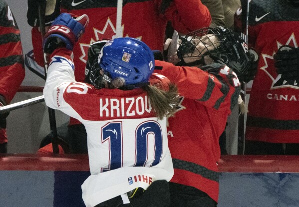 Czechia's Denisa Krizova (10) checks Canada's Renata Fast (14) by the boards doing the first period of a hockey match at the Women's World Championships in Utica, N.Y., Sunday, April 7, 2024. Canada beat Czechia 5-0.(Christinne Muschi/The Canadian Press via AP)